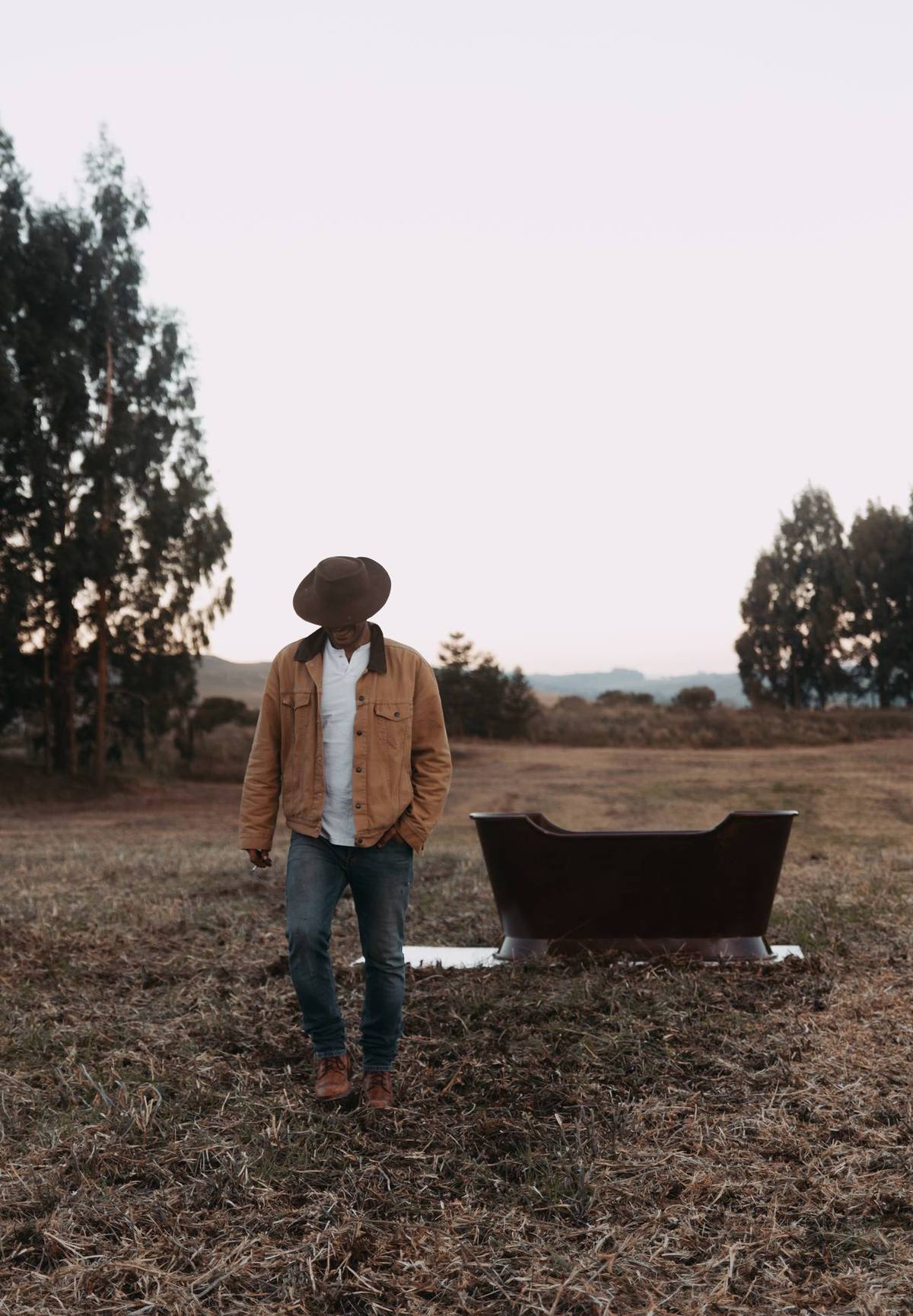 Victor R. R. Mendes caminhando no campo ao lado de uma peça do Galpón