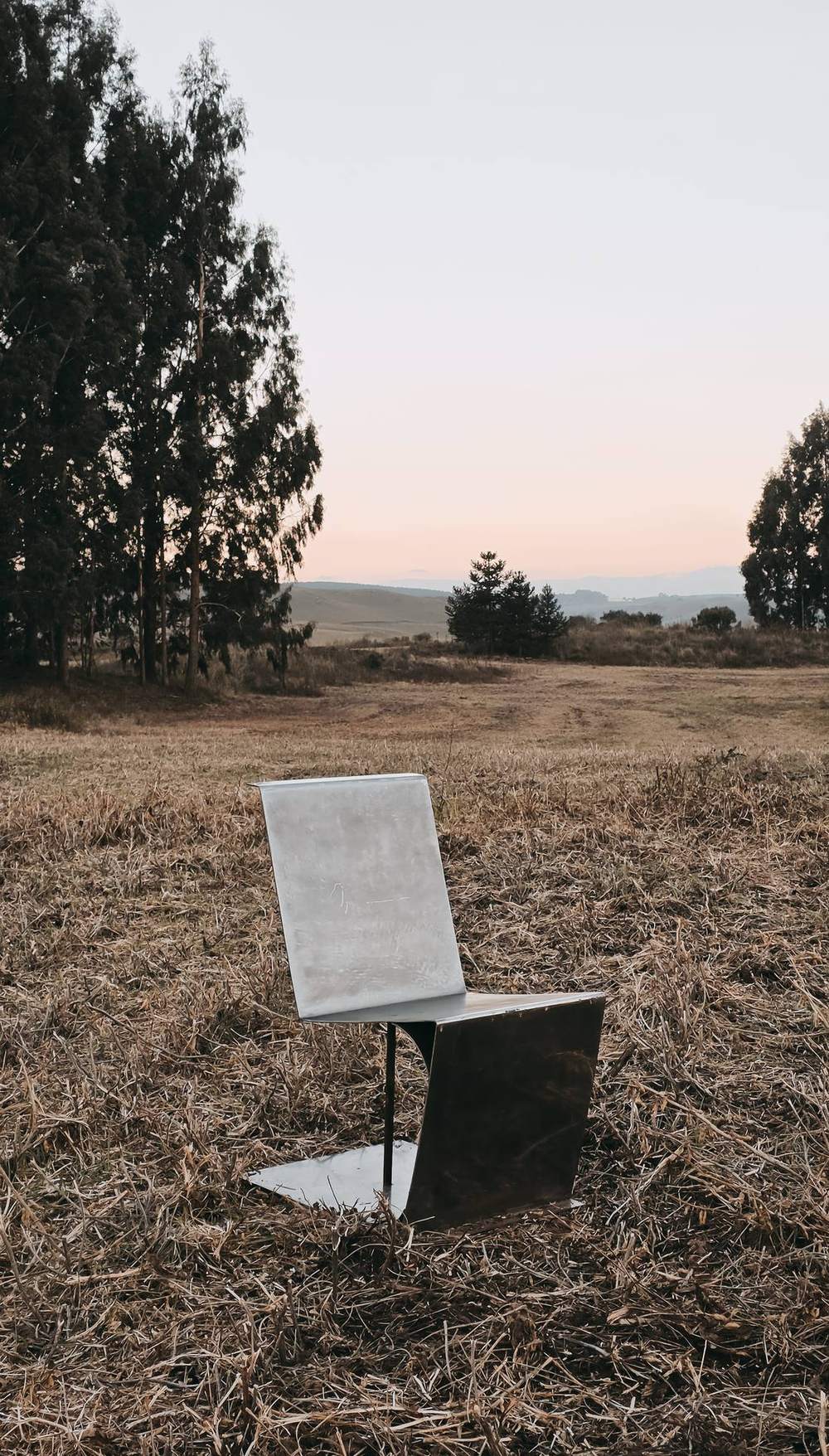 Cadeira no campo ao entardecer, encosto claro e base escura