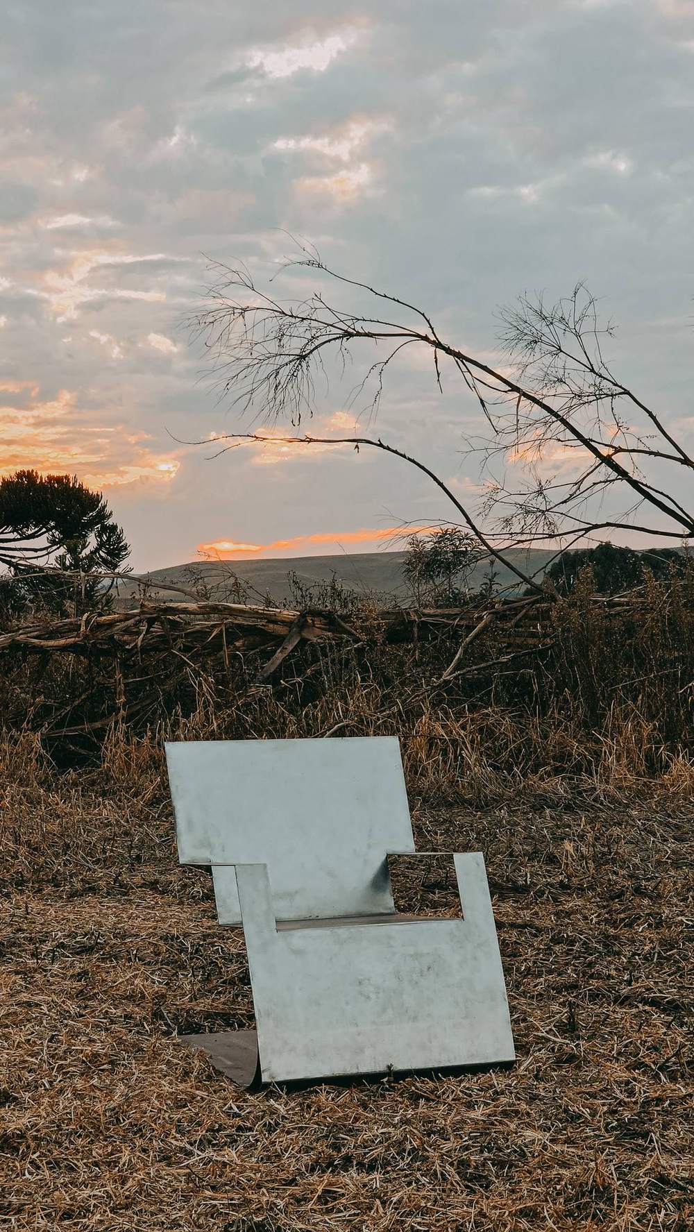 Poltrona no campo ao pôr do sol, vista de trás